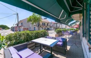 a patio with purple chairs and a table on a street at Apartman Iko Cista Provo in Cista Provo
