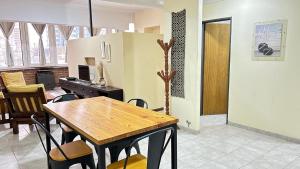 a dining room with a wooden table and chairs at Center Loft in General Roca