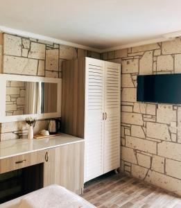 una cocina con una pared de ladrillo y un armario blanco en Limon Hotel, en Cesme
