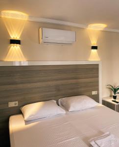 1 dormitorio con 1 cama blanca y aire acondicionado en Limon Hotel, en Cesme
