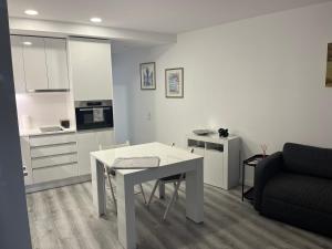 a kitchen and living room with a table and a couch at Apartamento Brisa do Mar in Sesimbra