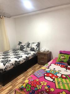 a bedroom with two beds and a rug on the floor at Casa Puente de Boyaca in Tunja