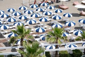 a bunch of blue and white umbrellas on a beach at CALEA Boutique Hotel in Bacoli