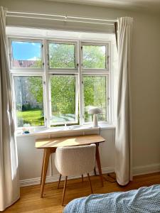 stół i krzesło przed oknem w obiekcie Cozy appartment for 2 in Aarhus w mieście Aarhus