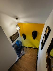 a hallway with a yellow wall with two black masks on the wall at Maison Pors Haor in Crozon