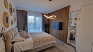 a bedroom with a bed and a tv and a window at Appartment Chindia Lake in Târgovişte