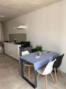 a kitchen with a blue table and chairs in a kitchen at TwENty2-Punat Apartments in Punat