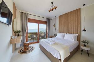 a hotel room with a bed and a balcony at seaandolive in Ammouliani