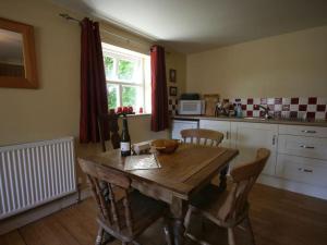 Una cocina con una mesa y sillas de madera con una botella de vino. en The Tree House, en Whitby 3 fotos más