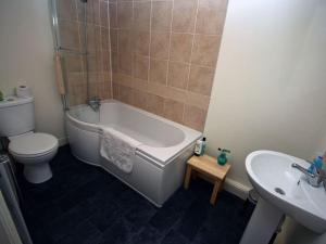 Un baño con bañera, inodoro y lavabo. en The Tree House, en Whitby