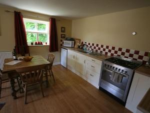 una cocina con una mesa y una estufa en The Tree House, en Whitby