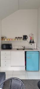 a kitchen with a counter with a sink and a dishwasher at Hilltop View Nikau Valley in Paraparaumu