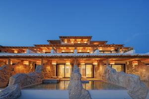 a building with a pool in front of it at WhiteArt Suites in Agrari