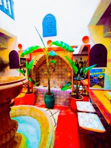 ein Zimmer mit Topfpflanzen auf einem roten Boden mit einem Brunnen in der Unterkunft riad cherif in Marrakesch