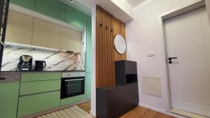 uma cozinha com armários verdes e brancos e uma porta em Luki's Centre Apartment em Pristina