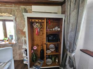 un mobile in legno con piatti sopra in una stanza di Holiday home in Dobrec 15115 a Dobreć