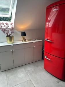 a red refrigerator in a kitchen with a table at Deluxe Loftapartement Big Size in Duisburg