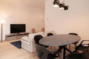 a living room with a table and a tv at Palazzo delle Guglie by Postcardsfrom in Verona +286 photos