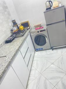 a kitchen with a microwave and a refrigerator at Dakhla sky blue in Dakhla