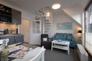a living room with a blue couch and a table at Rüm Hart II, Weestersir in Hörnum