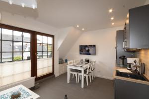 a kitchen with a table and chairs in a room at Rüm Hart II, Weestersir in Hörnum +14 photos