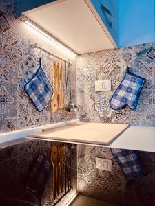 a shelf in a kitchen with blue and white wallpaper at Il Maestrale in La Maddalena