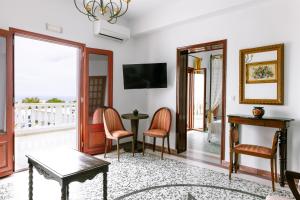 un salon avec une table, des chaises et un miroir dans l'établissement Kaminia Holiday Homes, à Éxo Goniá