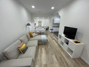 a living room with a couch and a flat screen tv at O Prior - Aposentos in Urzelina