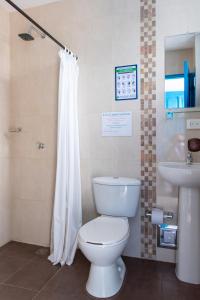 y baño con aseo blanco y lavamanos. en Casa Caribe Colonial en Barranquilla