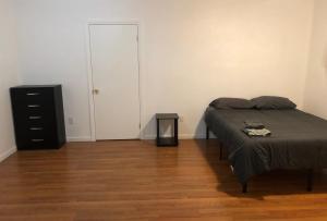 a bedroom with a bed and a dresser and a door at Large and private apartment can sleep up to 8 people comfortably with direct NYC Manhattan train only 5 minute walk away in Elizabeth +6 photos