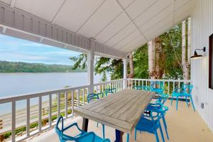 a porch with a wooden table and blue chairs at Morning Star Retreat in Vashon