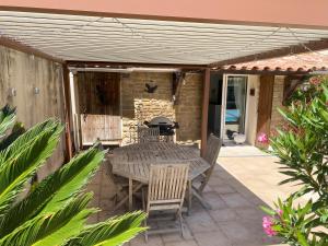 un patio avec une table, des chaises et un grill dans l'établissement Villa Provençale avec piscine privative, à Saint-Cyr-sur-Mer
