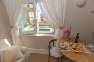 a table with a plate of food on it next to a window at Back in Time Luxury Dubrovnik 2 in Dubrovnik