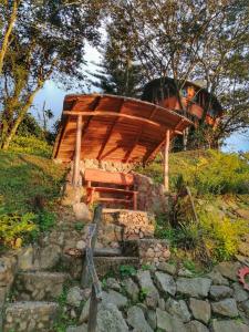 una estructura de madera situada en la cima de una colina en Yaque Glamping, en San Francisco