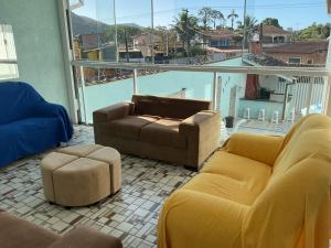 sala de estar con muebles de color amarillo y ventana grande en Pousada Sol & Mar, en Ubatuba