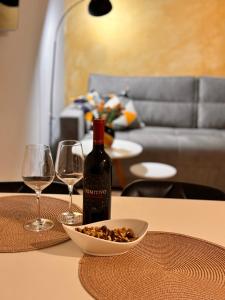 a bottle of wine sitting on a table with two glasses at Apartman AN12 in Neum