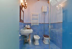 Terre Di Himera في Buonfornello: حمام من البلاط الأزرق مع حوض ومرحاض