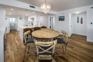 uma cozinha e sala de jantar com uma mesa de madeira e cadeiras em Surf Dweller 406 condo em Fort Walton Beach