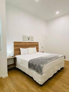 a bedroom with a large white bed with a wooden floor at Casa Victoria in Flores
