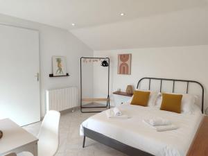 Un dormitorio con una cama, una mesa y un espejo. en Studio au coeur de Guérande, en Guérande