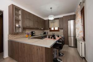 a kitchen with wooden cabinets and a large counter top at Giorgia's home in Kokkari