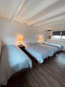 a room with three beds in a row with lamps at Boathouse Amsterdam in Amsterdam