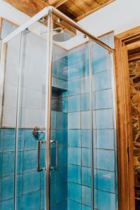 y baño con ducha y azulejos azules. en Terre Di Himera en Buonfornello