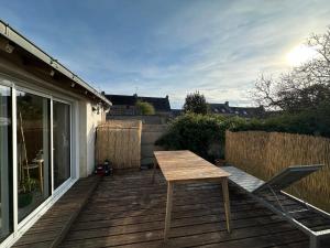 una mesa de madera y una silla en la cubierta en Studio au coeur de Guérande, en Guérande
