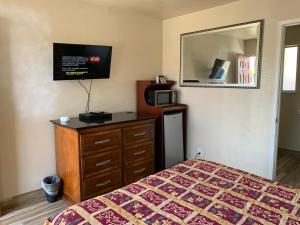 een slaapkamer met een bed, een dressoir en een spiegel bij Jerry's Motel in Oakdale