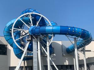 a blue roller coaster in front of a building at Apartament Aquapark Gold 8 in Reda