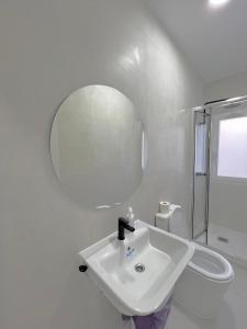 a white bathroom with a sink and a mirror at Hostel OASIS in Madrid