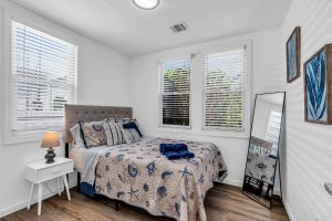 a bedroom with a bed and a mirror and windows at Highly Rated Beach House - 6 Badges, Outdoor Patio, Grill - 3 Blocks to Beach & Boards in Belmar