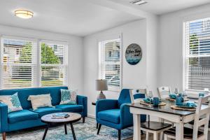 a living room with a blue couch and a table at Highly Rated Beach House - 6 Badges, Outdoor Patio, Grill - 3 Blocks to Beach & Boards in Belmar