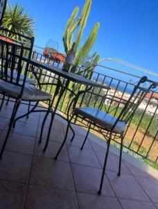 een tafel en stoelen op een balkon met een plant bij villa da sogno in vetro in Castellammare del Golfo